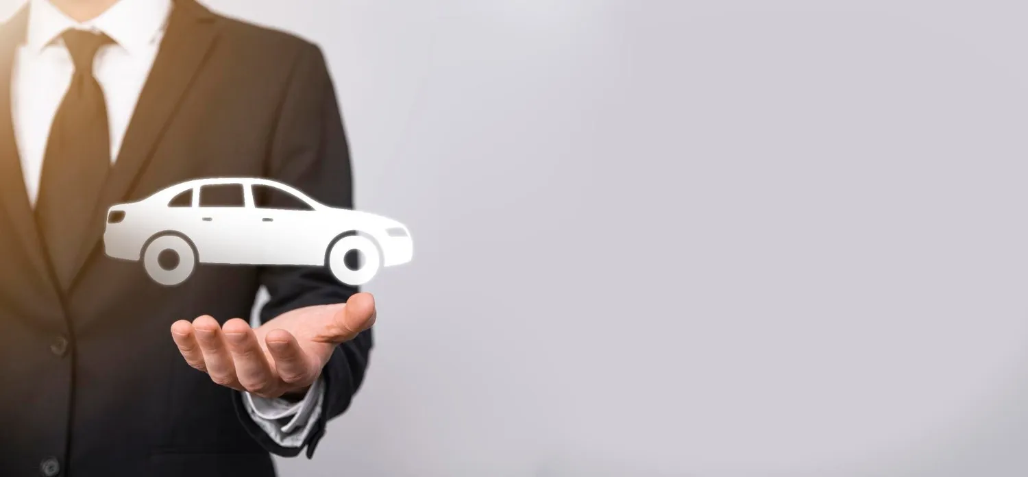 Person holding a small car model in an open hand