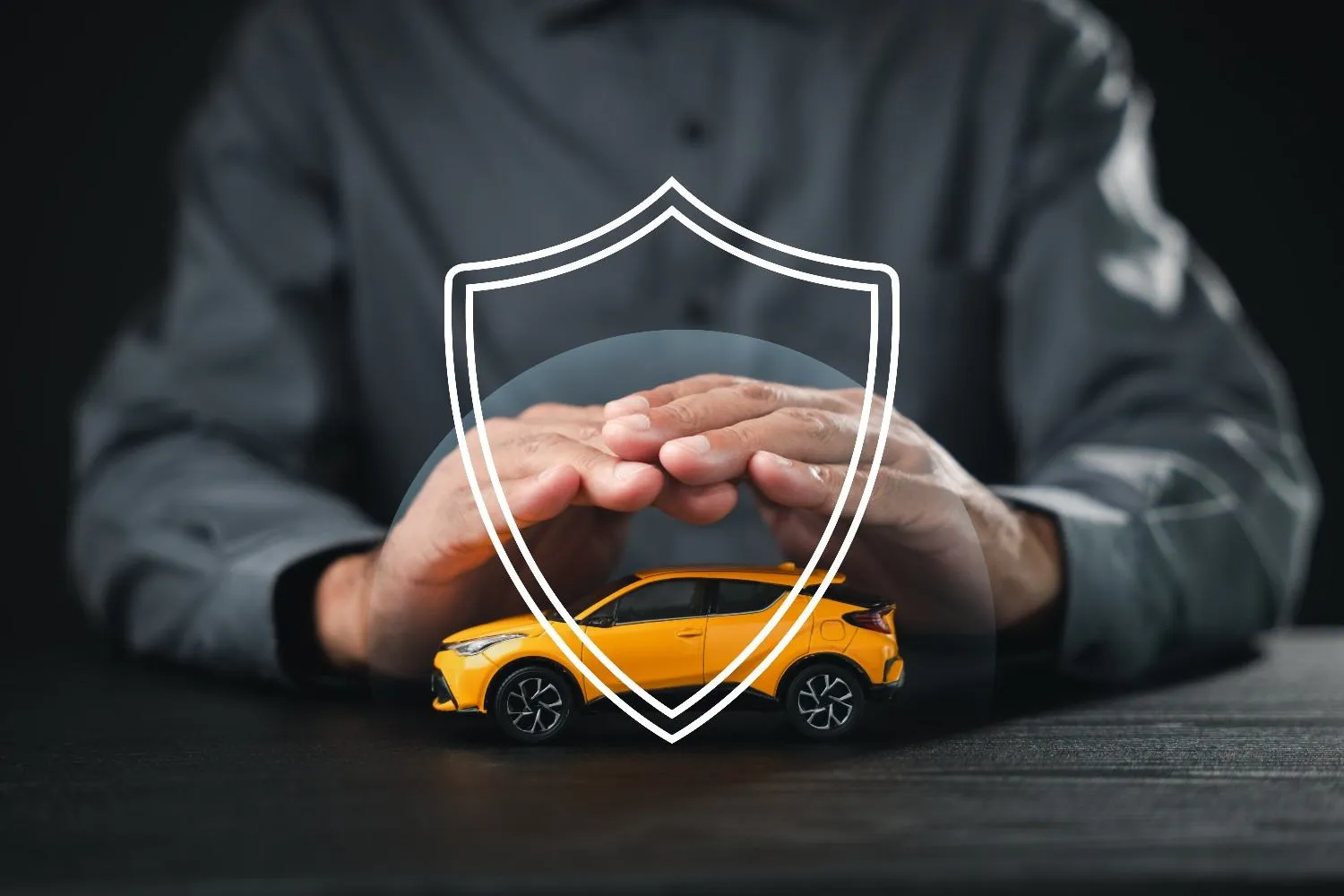 Hands held over a toy car under a shield outline